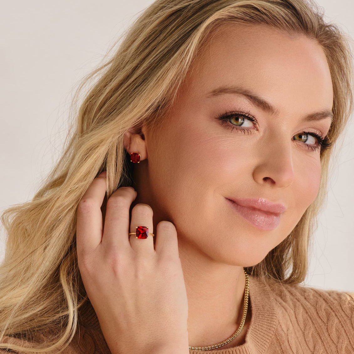 Hand model wearing 10 mm cushion cut lab grown ruby ring in 14k gold statement cocktail ring.
