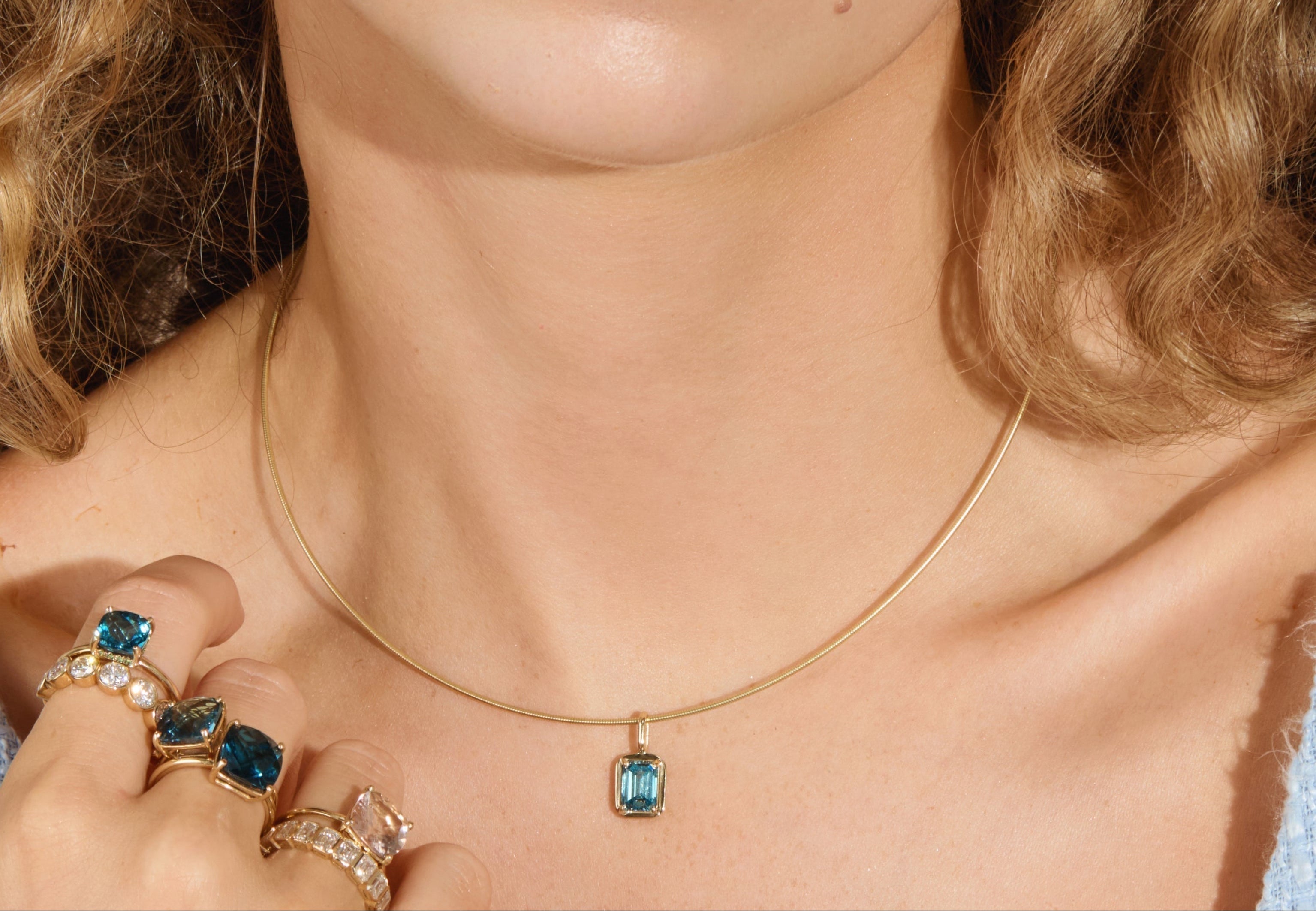 Woman wearing blue diamond necklace.