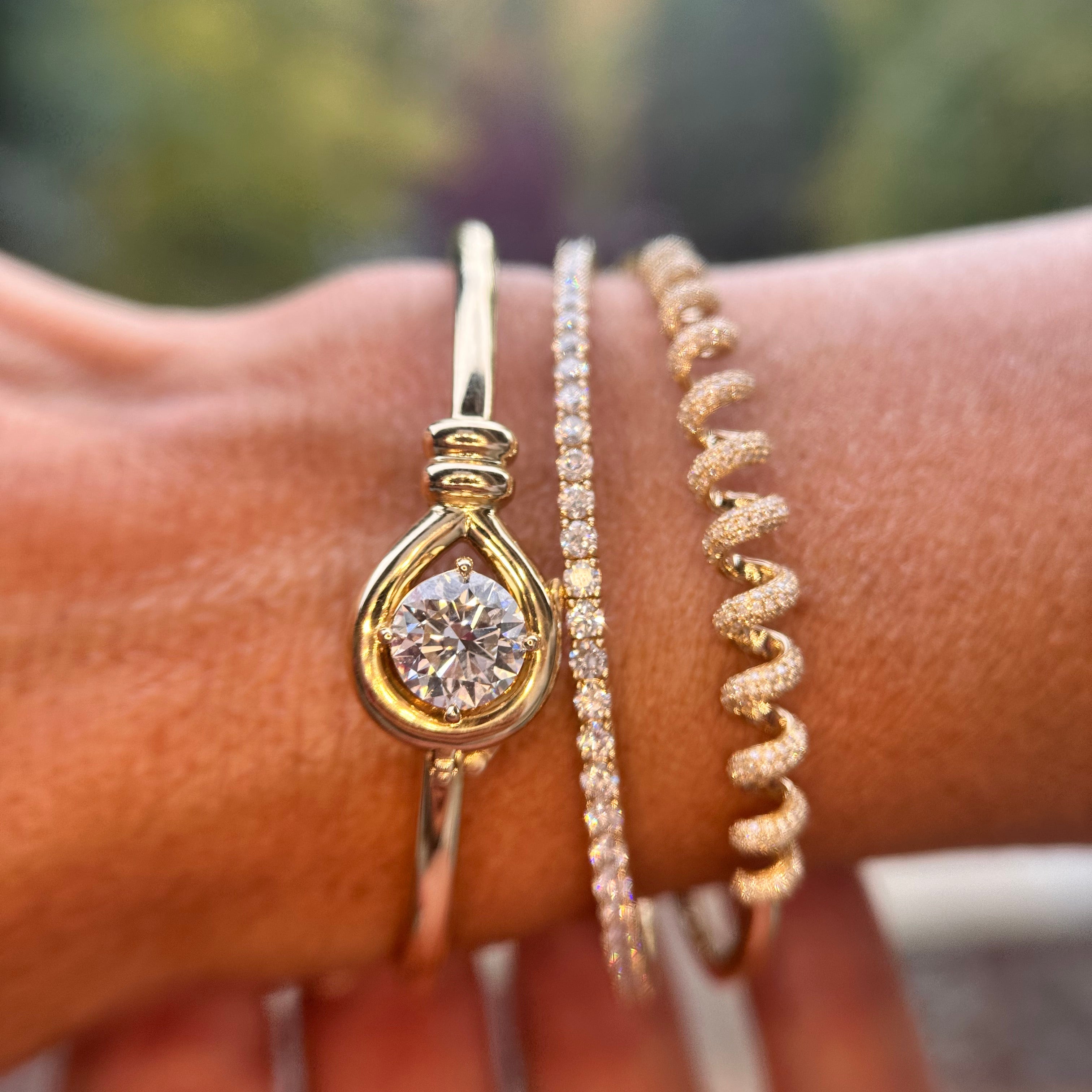 Solid Gold bracelets stacked on a wrist