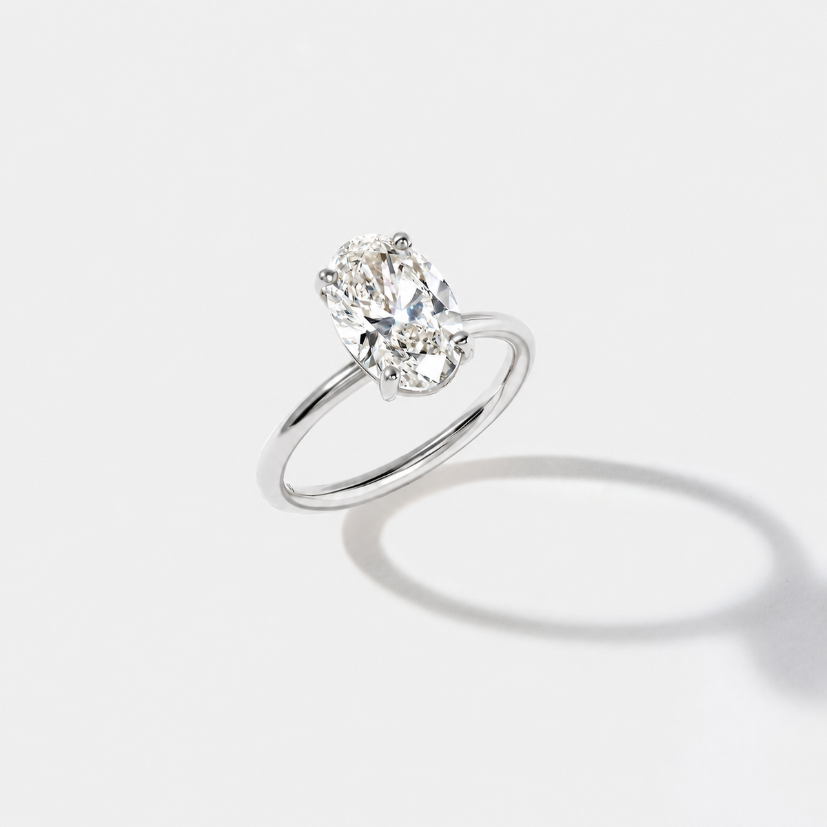 Elongated oval solitaire diamond engagement ring in polished white gold, shown from the front.
