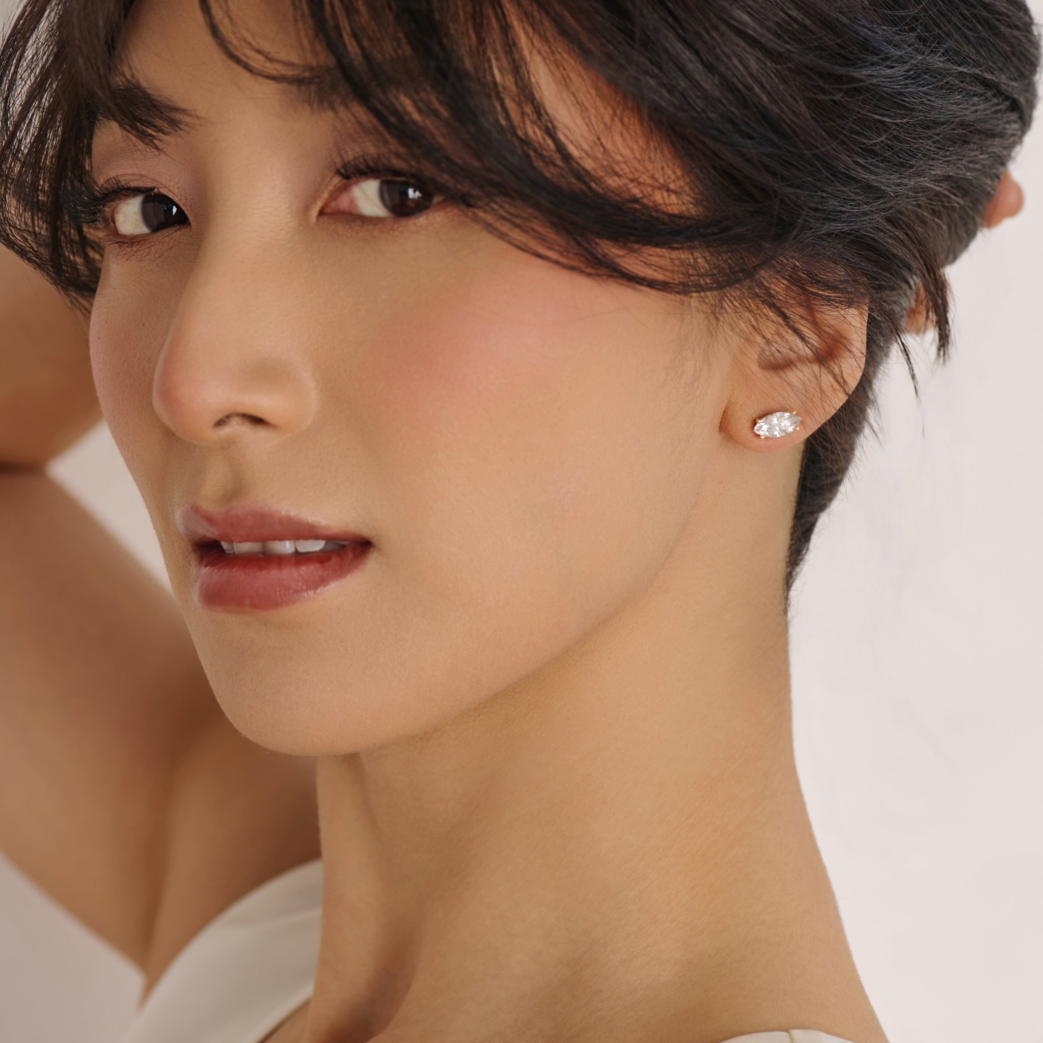 Model wearing marquise diamond stud earrings in solid 14k gold with lab grown diamonds