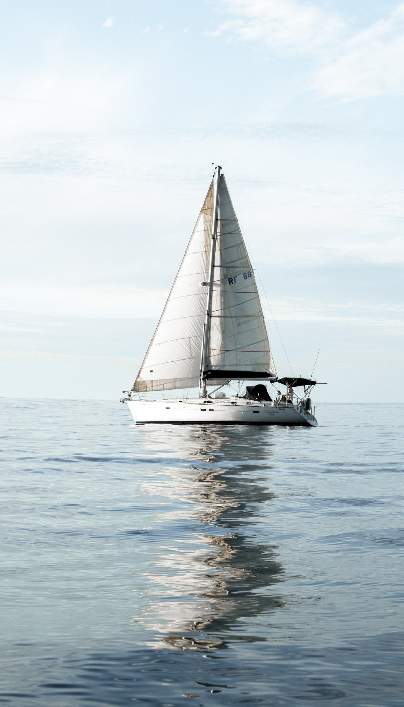 Sailboat on the ocean along the New England coast reflecting a coastal luxury lifestyle and sense of place