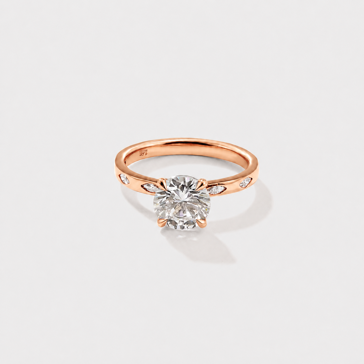 Classic round solitaire diamond ring with delicate marquise diamond side accents.