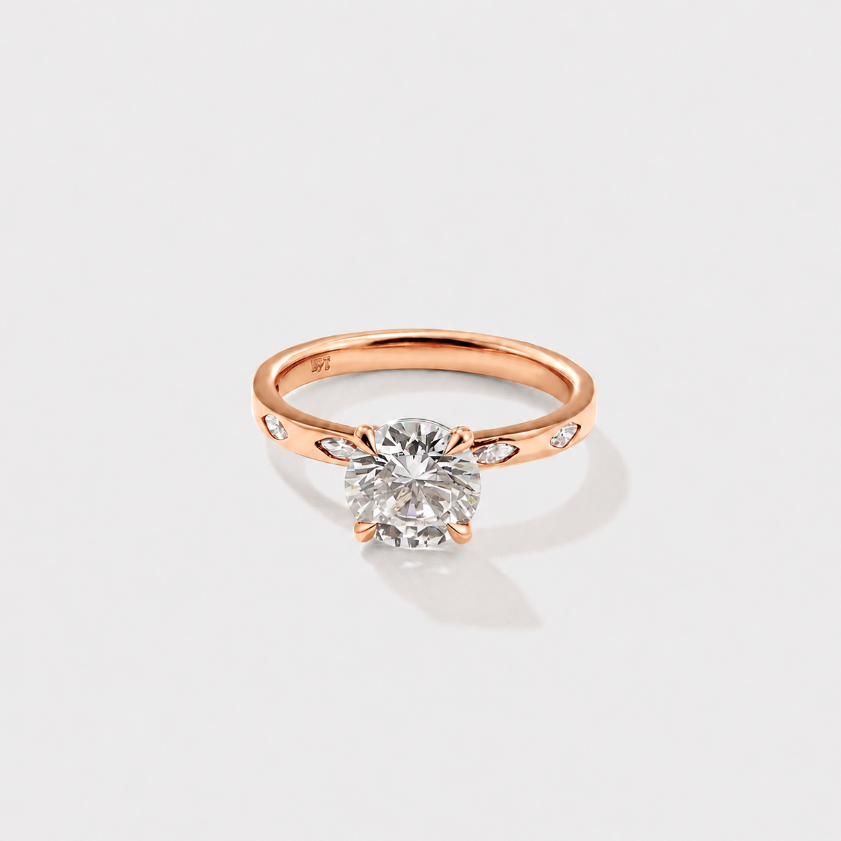 Classic round solitaire diamond ring with delicate marquise diamond side accents.