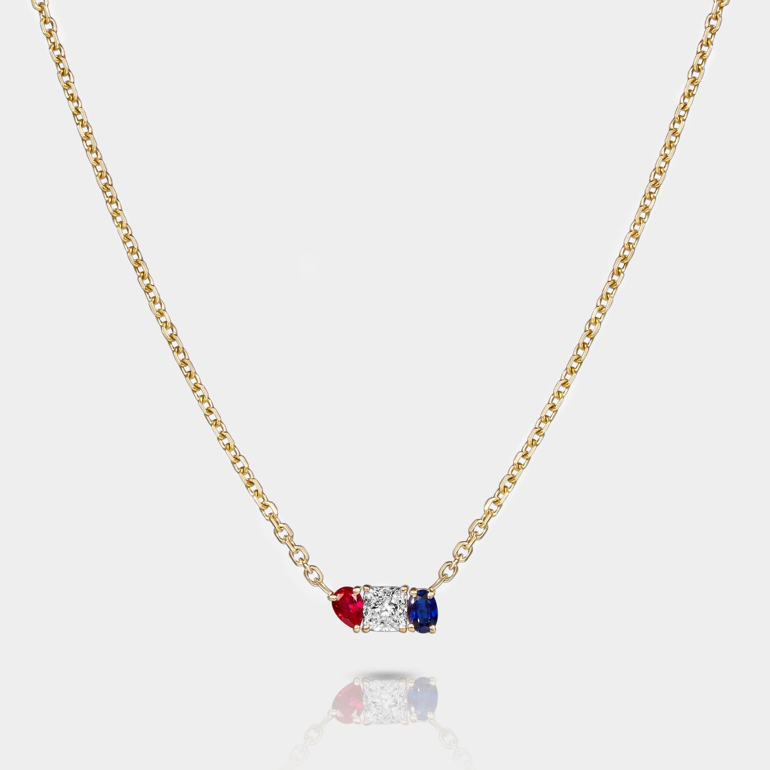 Americana necklace in 14k gold featuring lab-grown ruby, diamond, and sapphire in a vertical bezel-set pendant design on a gold chain