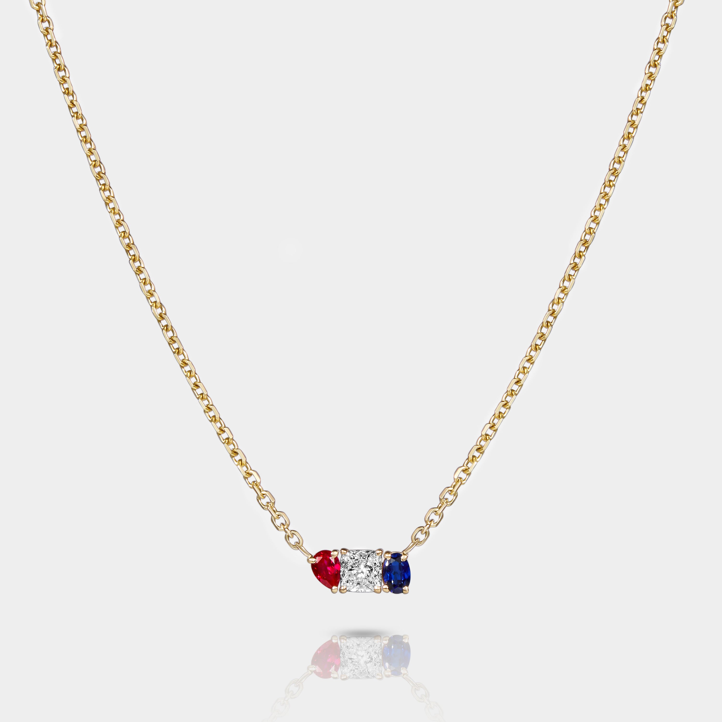 Americana necklace in 14k gold featuring lab-grown ruby, diamond, and sapphire in a vertical bezel-set pendant design on a gold chain