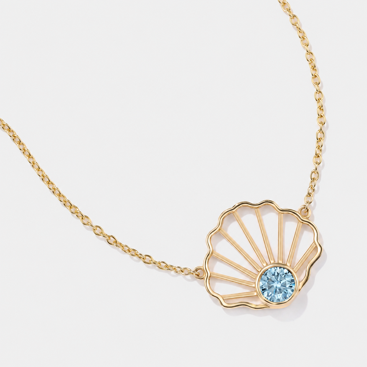 Natural aquamarine scallop necklace in solid 14k gold with an open shell design and adjustable gold chain.
