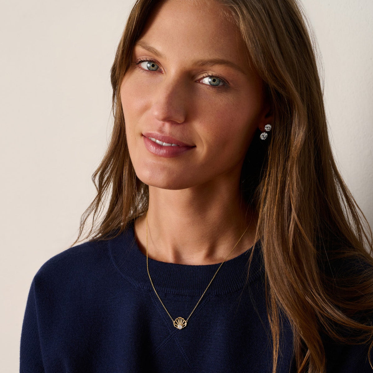 Close-up of a solid 14K gold scallop shell pendant with a 0.20 carat lab-grown diamond and delicate shell detailing.