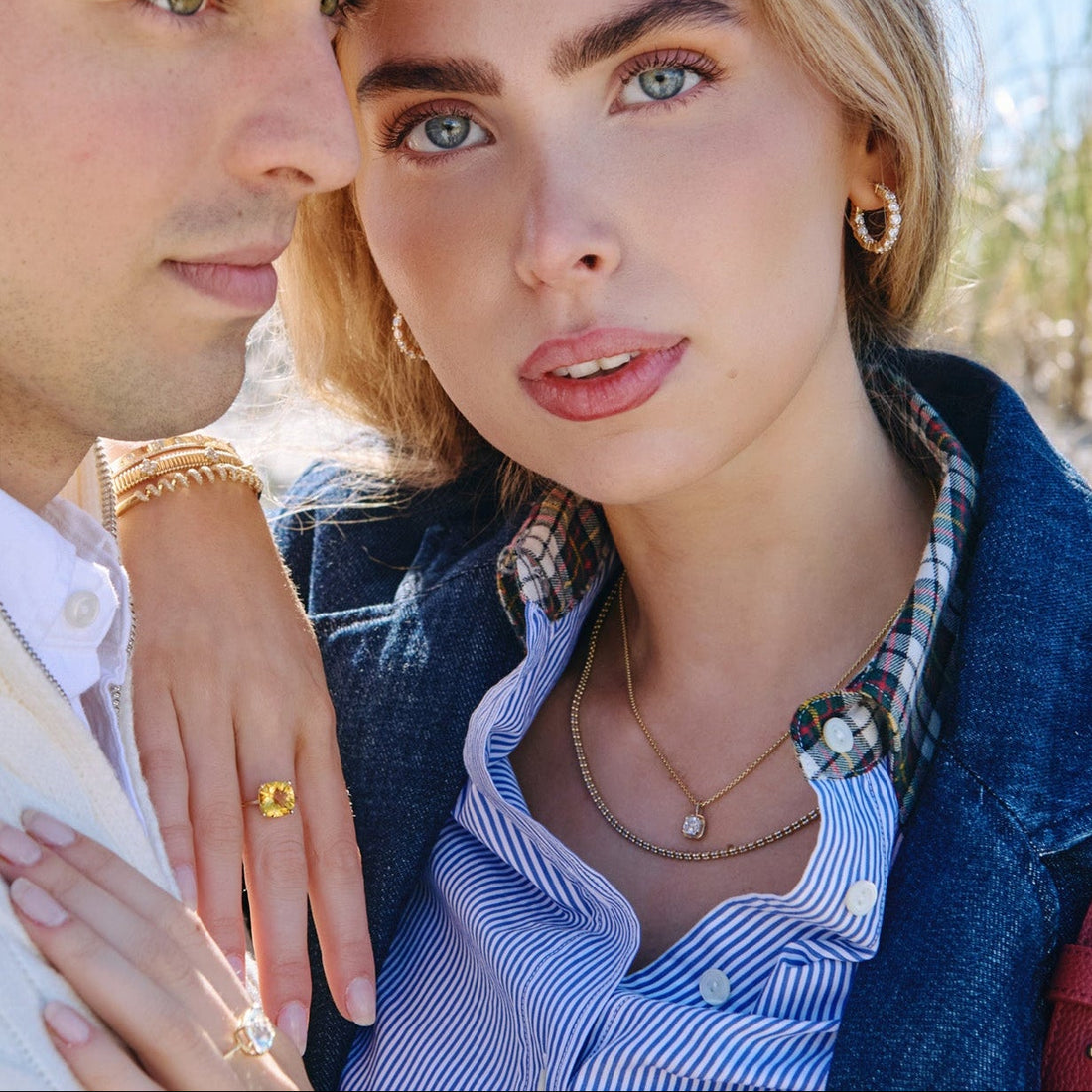 woman wearing a citrine ring and a stack of gold bracelets