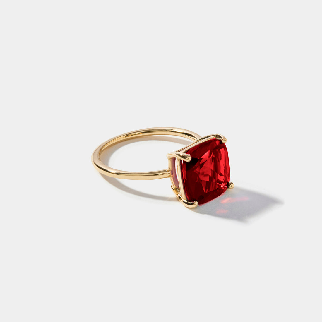 Large cushion cut lab grown ruby ring in solid 14k gold with vibrant red ruby gemstone in a modern cocktail ring setting.