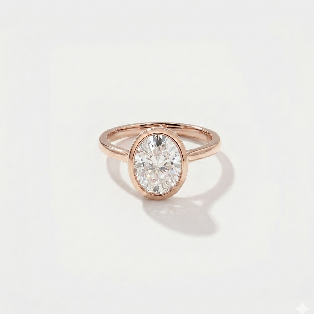 Rose gold oval bezel engagement ring with a lat grown diamond on a light gray background