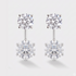 A round pair of stud earrings with a round diamond drop dangle below it. 