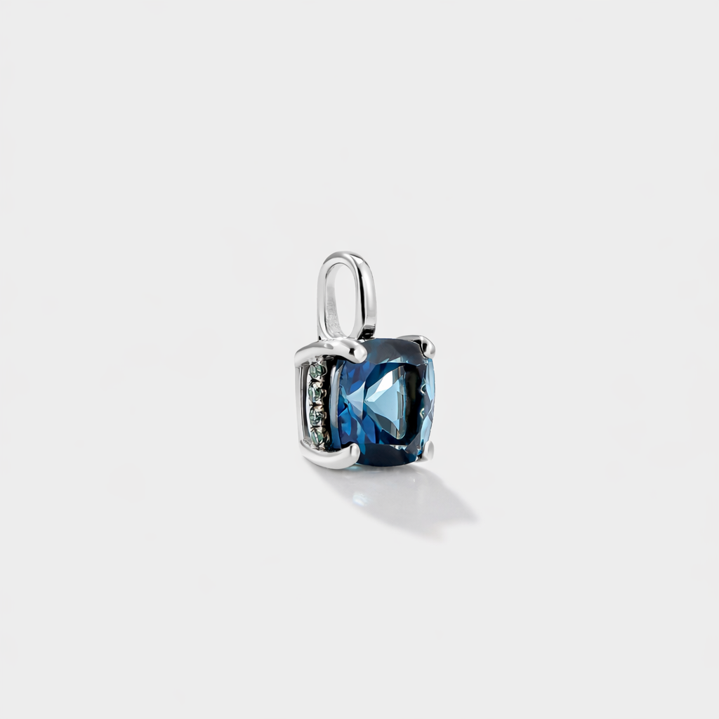Close-up of a London Blue Topaz pendant necklace on model, featuring a deep ocean-blue gemstone and lab-grown diamond details in solid gold.