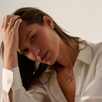 Woman wearing a 14K solid gold scallop diamond necklace, an original Cape Cod-inspired coastal jewelry design by Cove Fine Jewelry.