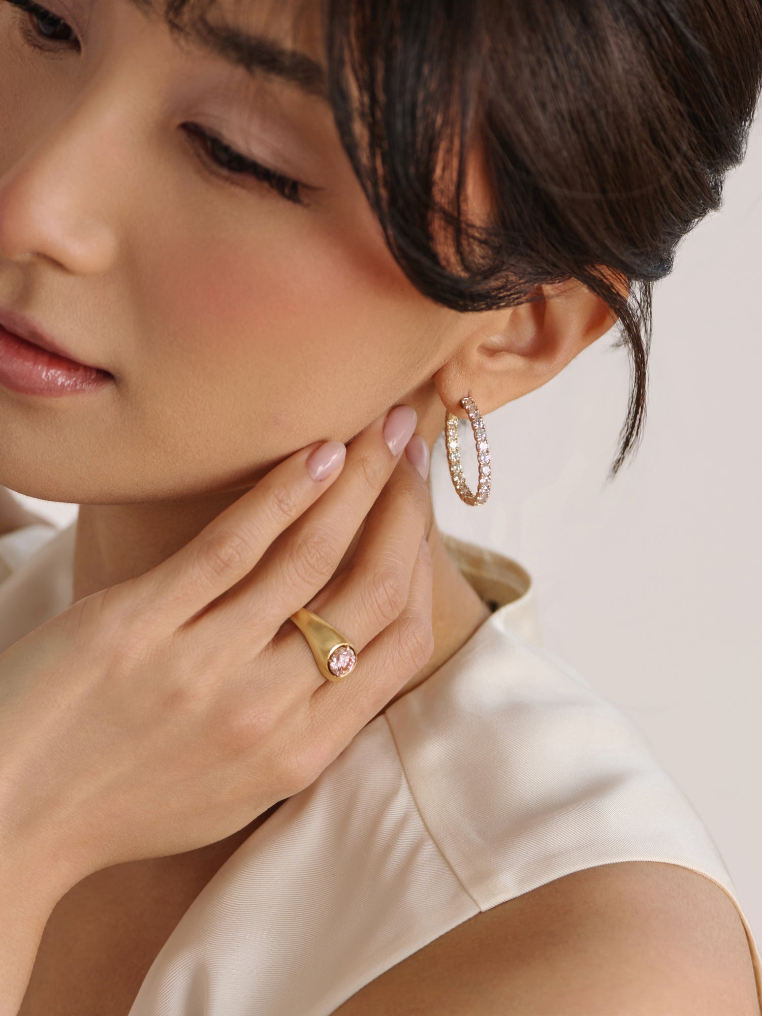 Woman wearing pink diamond ring styled with coastal light and soft beach inspired tones