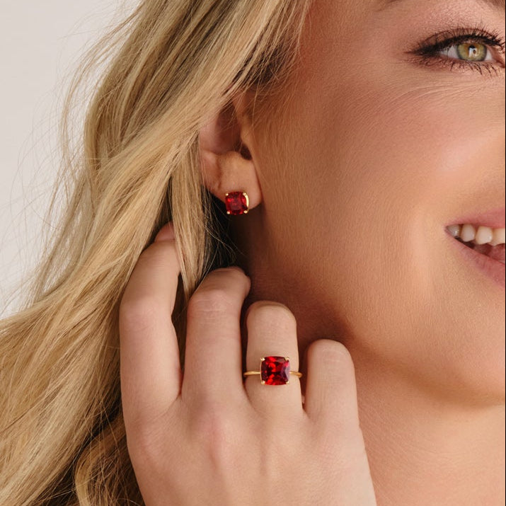 Close up of hand wearing bold cushion ruby ring with lab grown ruby gemstone set in solid gold.