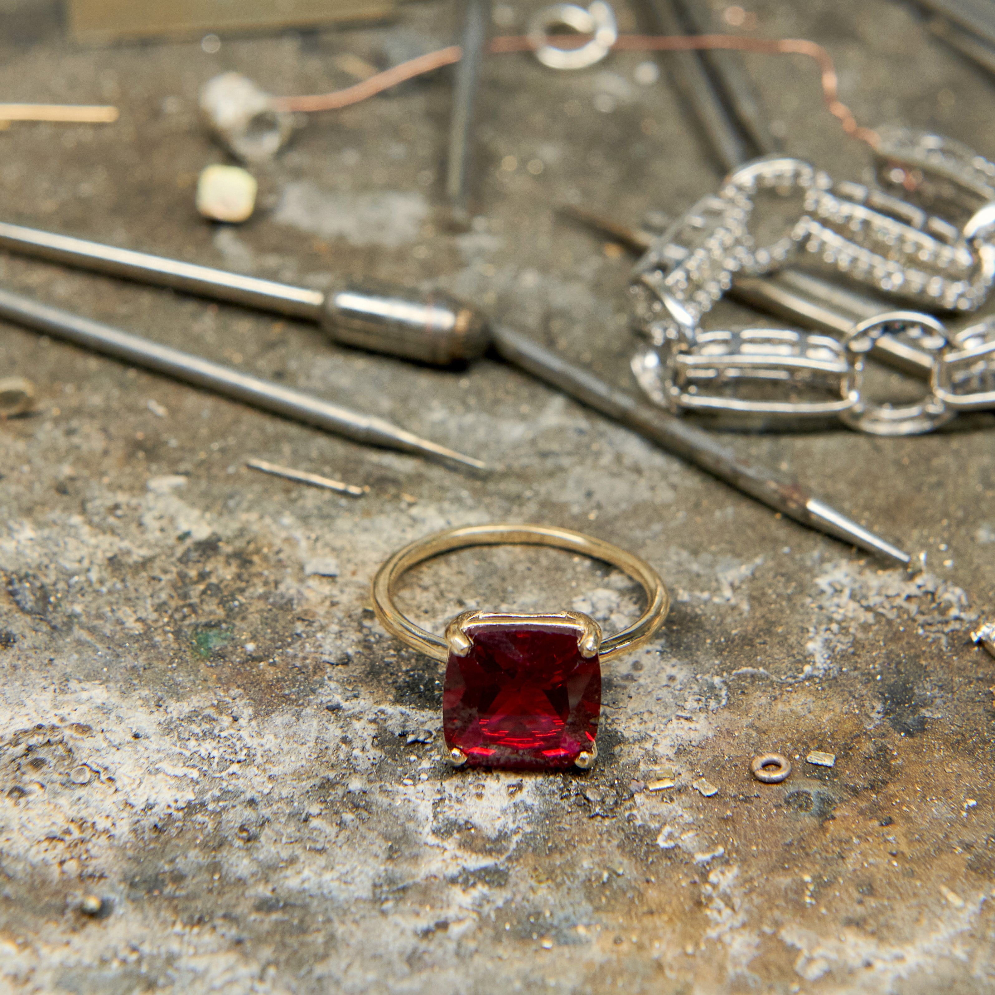 Cushion cut ruby statement ring with 10 mm lab grown ruby gemstone set in polished 14k gold.