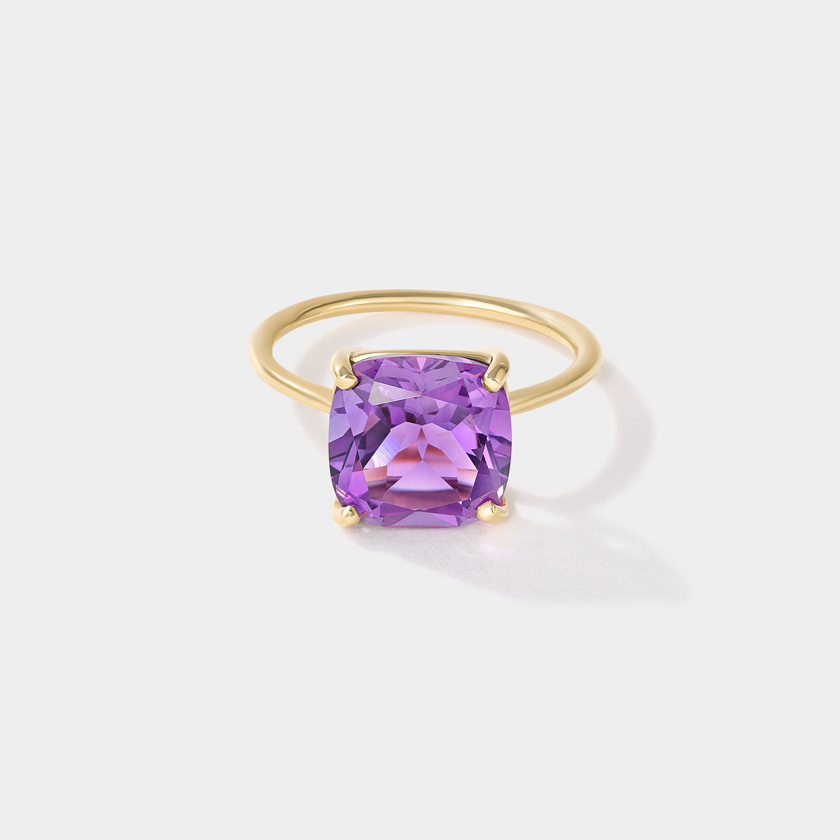 Purple cushion-cut amethyst solitaire ring in solid 14k yellow gold with four-prong setting, Drift by Cove Fine Jewelry.