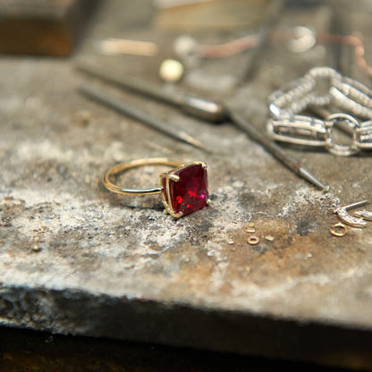 Cushion cut ruby statement ring with 10 mm lab grown ruby gemstone set in polished 14k gold.