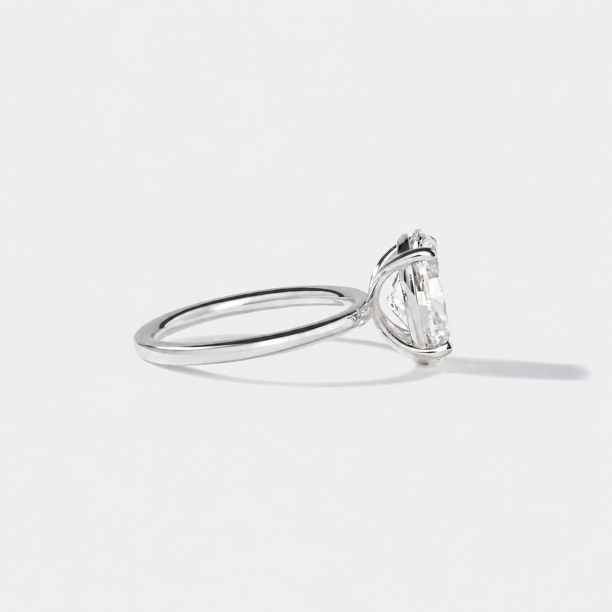 Side profile of an elongated oval diamond engagement ring in white gold with a four-prong setting and slim band.