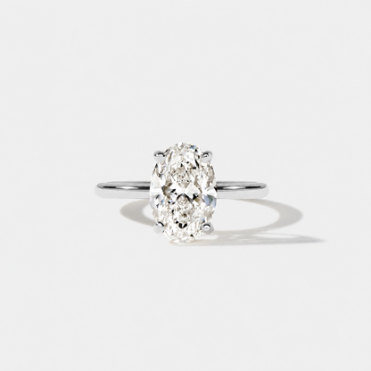 Front view of an elongated oval diamond engagement ring in polished white gold with a classic four-prong solitaire setting.