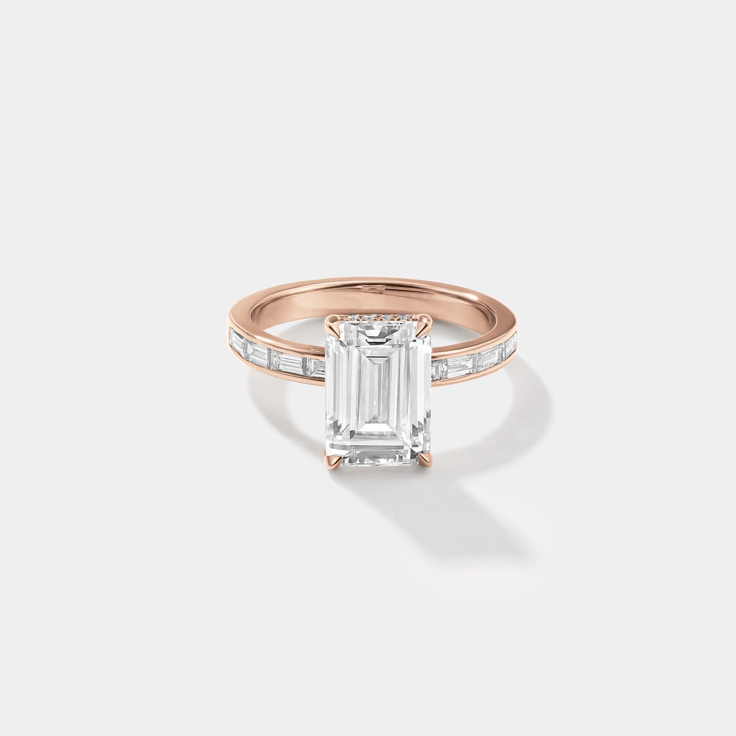 Emerald-cut lab-grown diamond engagement ring with a hidden halo and channel-set band in rose gold