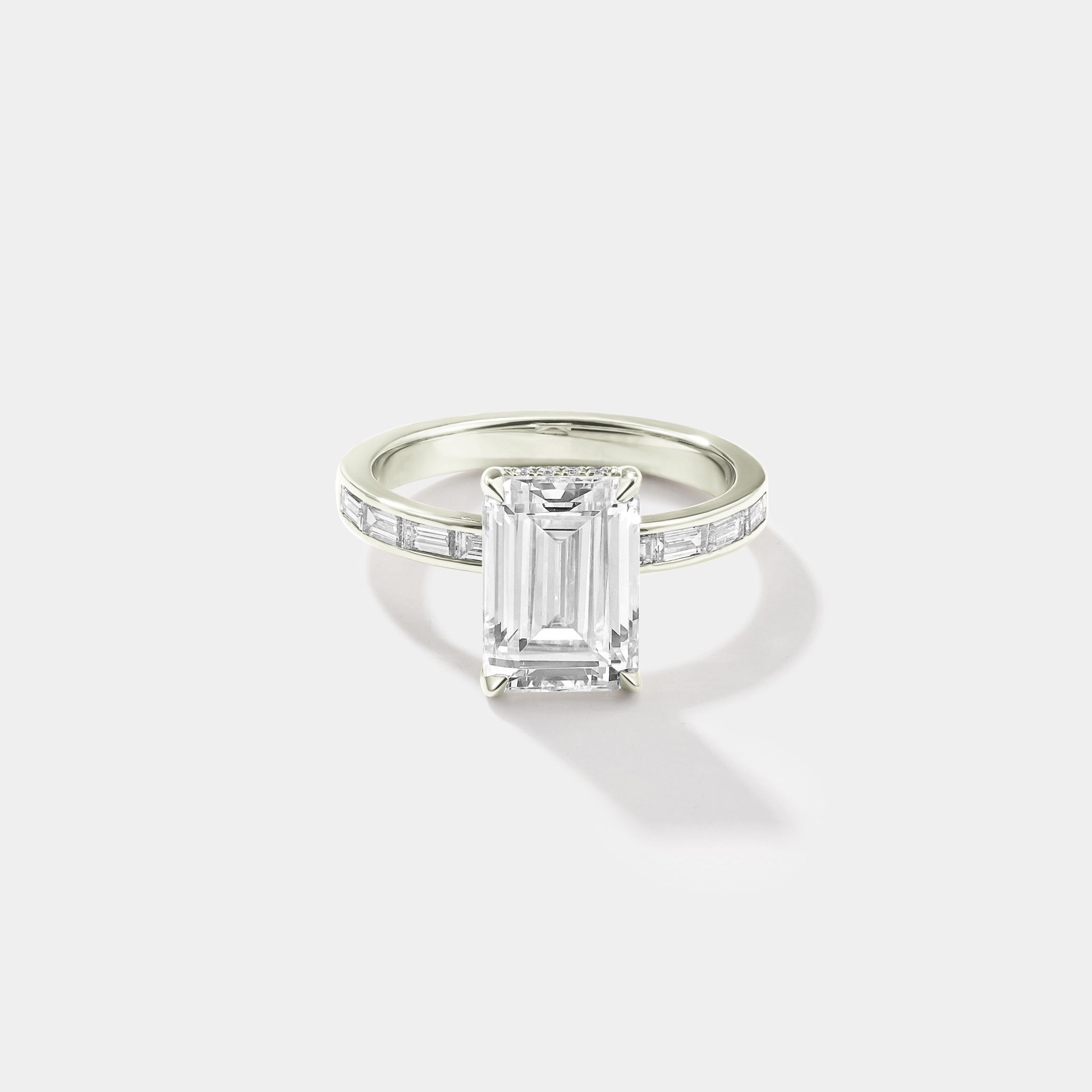 Emerald-cut lab-grown diamond engagement ring with a hidden halo and channel-set band in white gold