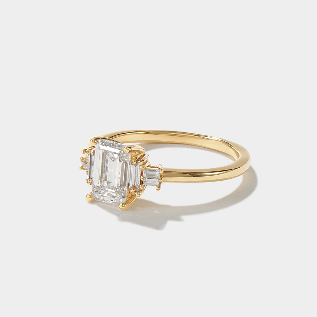 Angled view of an emerald-cut lab-grown diamond ring with six baguette side diamonds