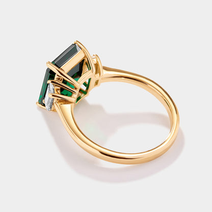 Emerald cut lab grown emerald ring with step cut trapezoid diamond side stones in solid 14k gold