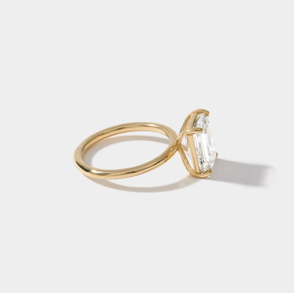 Side-view of emerald cut solitaire engagement ring handcrafted by Cove Fine Jewelry