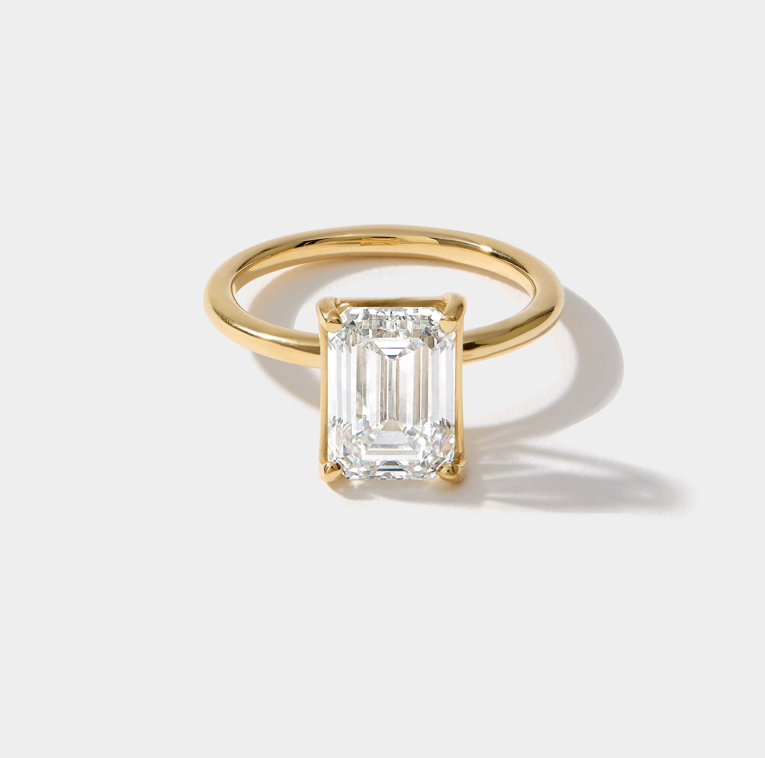 Emerald cut solitaire lab-grown diamond engagement ring in 14K yellow gold by Cove Fine Jewelry
