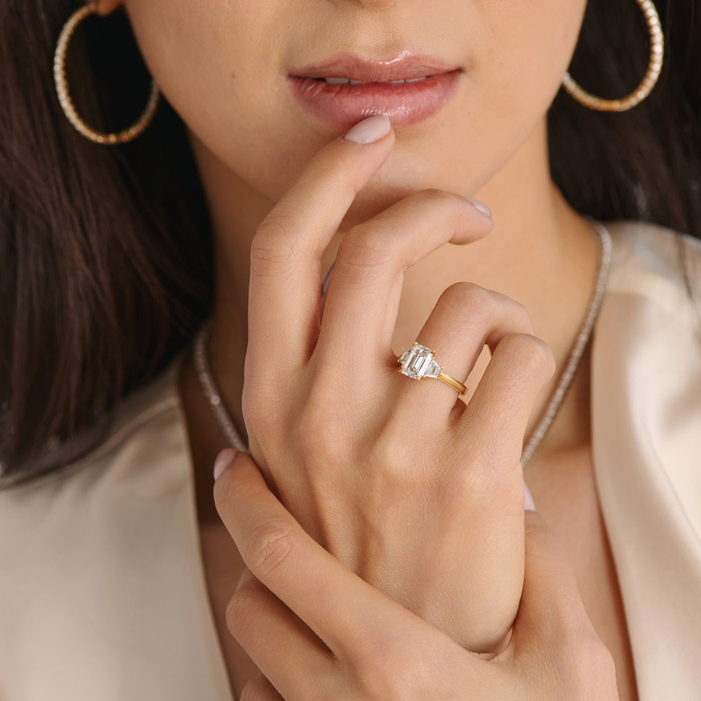 Close-up of emerald cut three stone engagement ring handcrafted by Cove Fine Jewelry