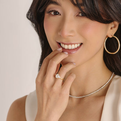 Close-up of emerald cut three stone engagement ring handcrafted by Cove Fine Jewelry