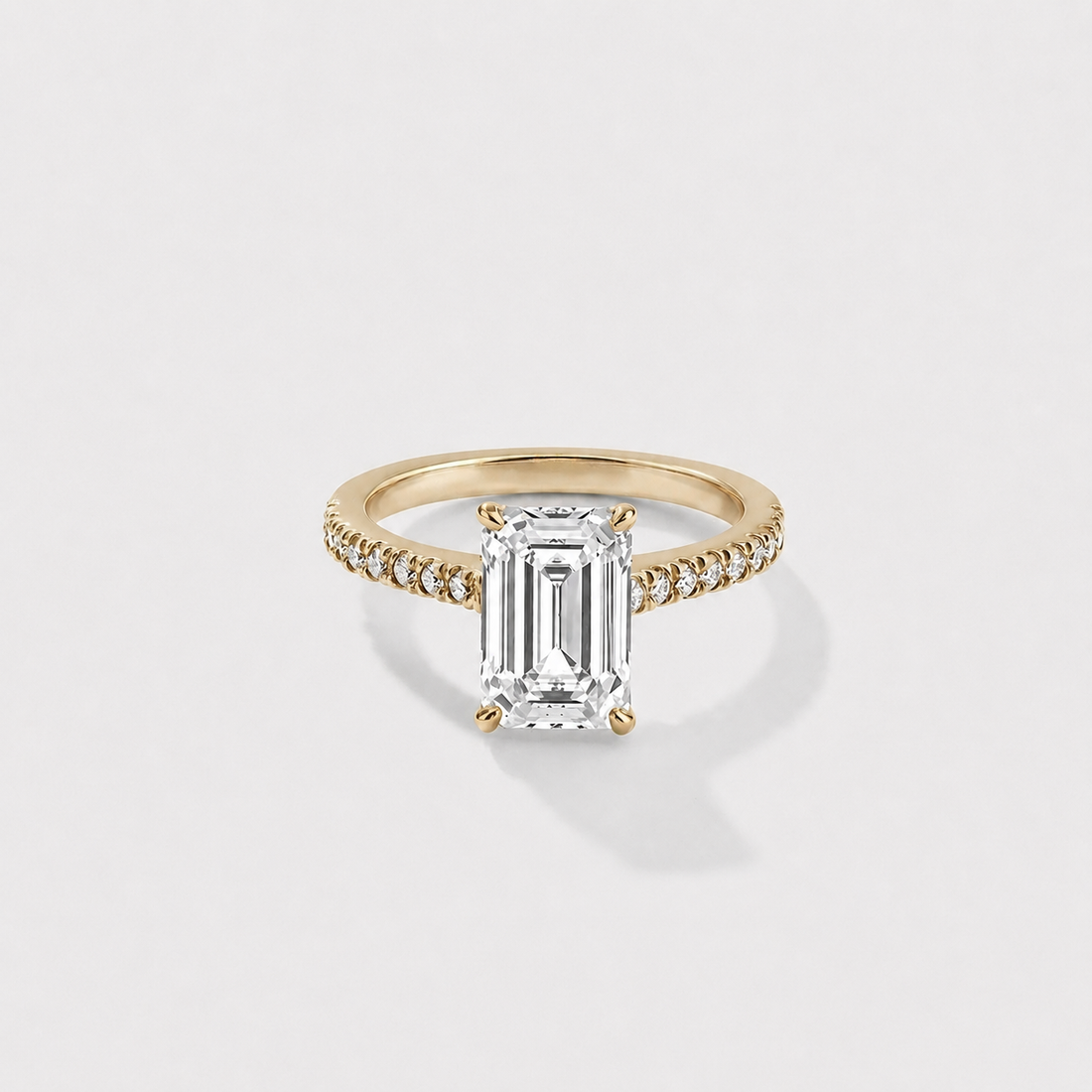 Emerald-cut lab-grown diamond engagement ring with a hidden halo and cathedral pavé band in yellow gold
