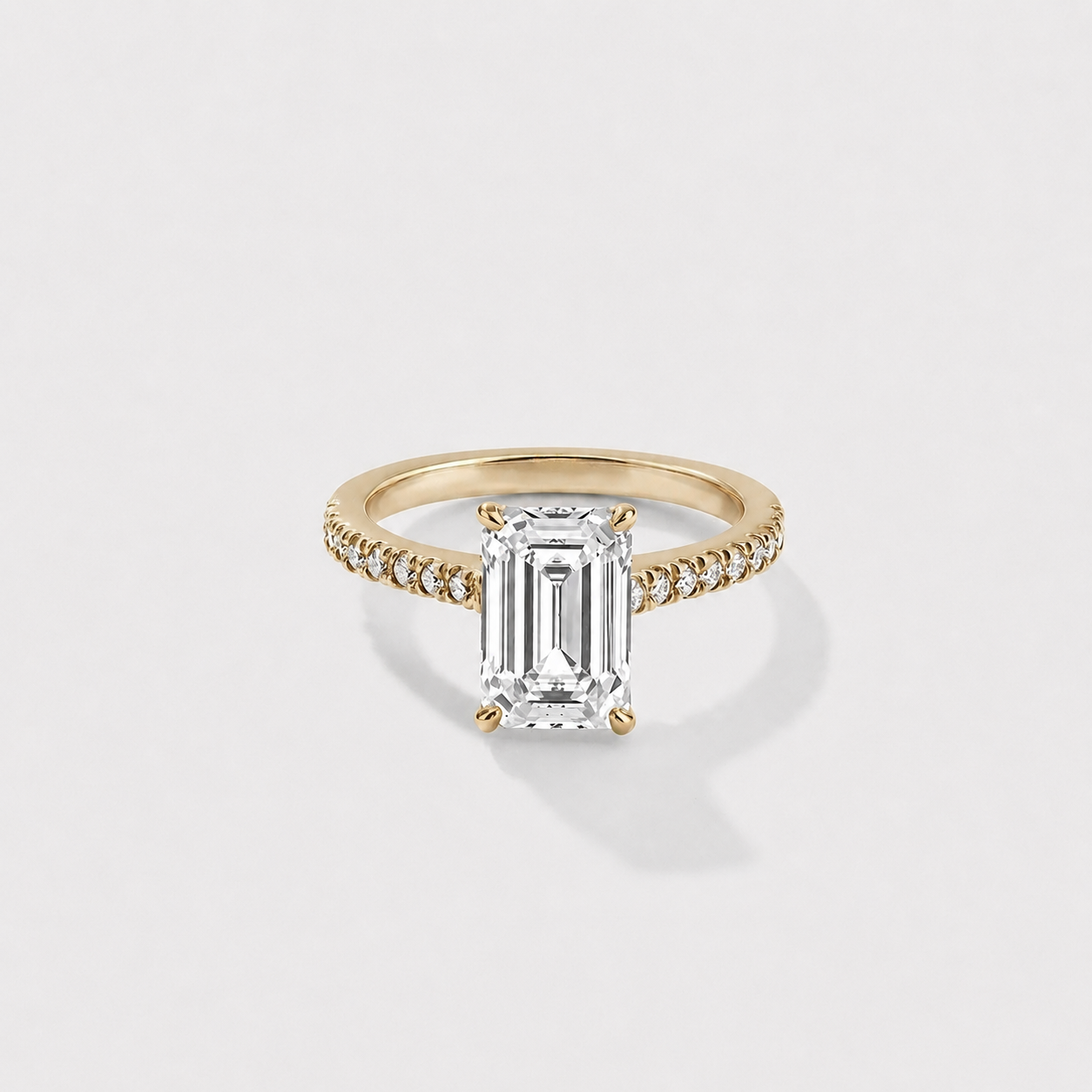 Emerald-cut lab-grown diamond engagement ring with a hidden halo and cathedral pavé band in yellow gold