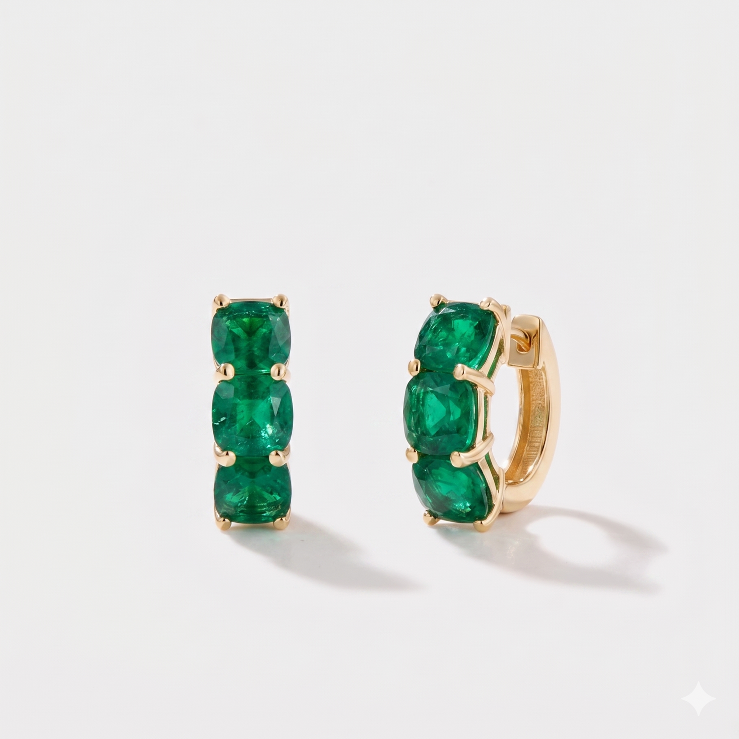 Close-up of cushion cut emerald hoop earrings on ear in 14k gold 