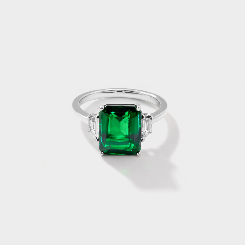 white gold lab grown emerald three stone ring with emerald cut emerald and trapezoid diamonds