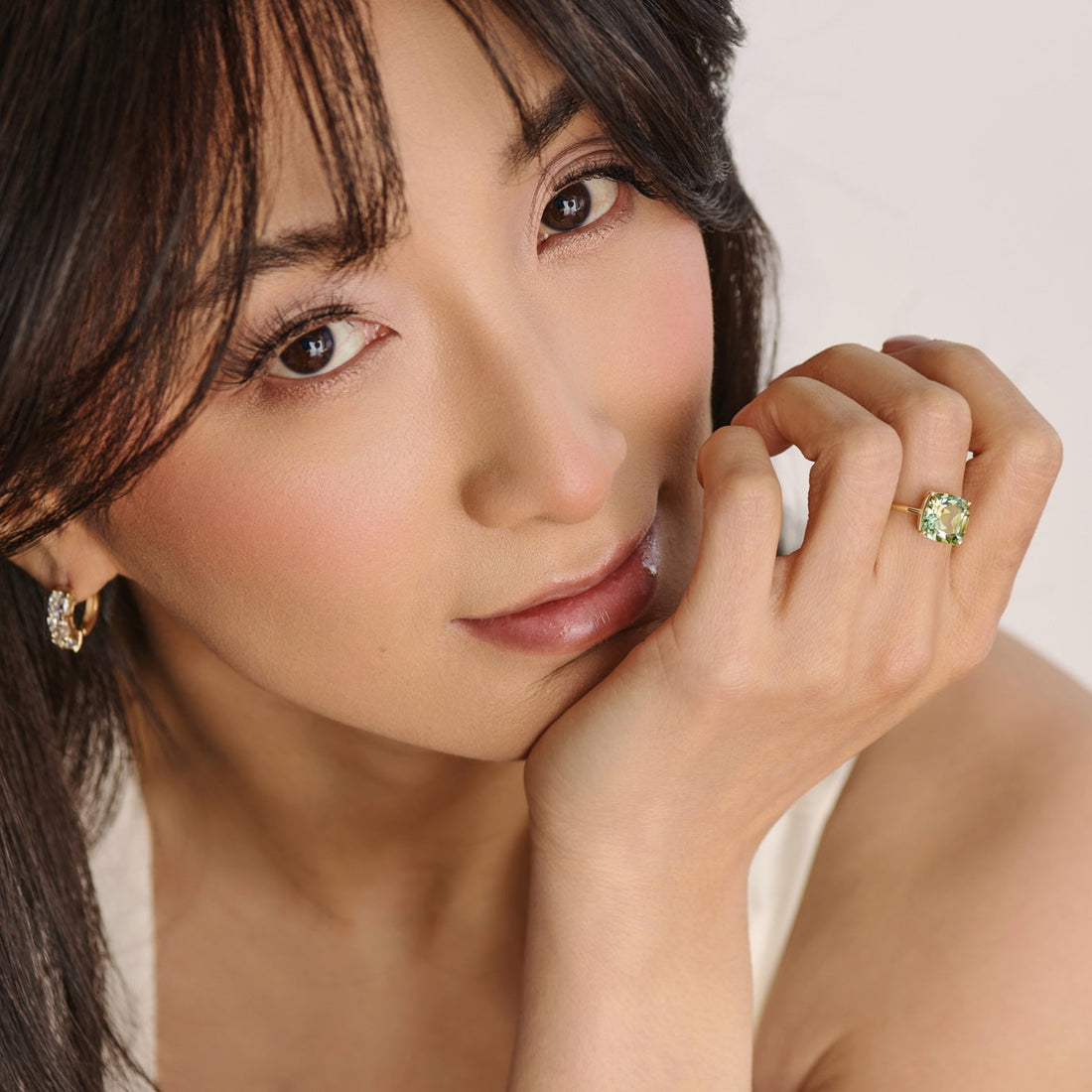 Model wearing a large cushion-cut green amethyst statement ring in 14K yellow gold.