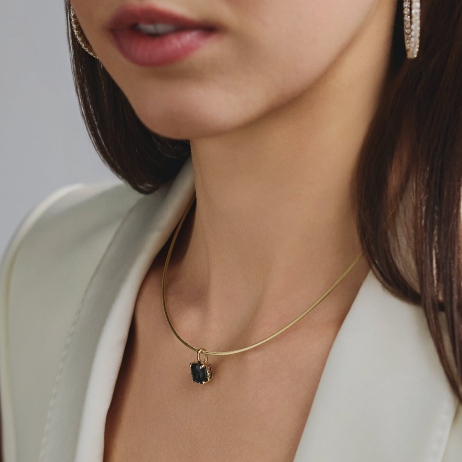 Model wearing a 14k gold London Blue Topaz pendant with diamond accents, inspired by Cape Cod and designed to complement the Wequassett ring.