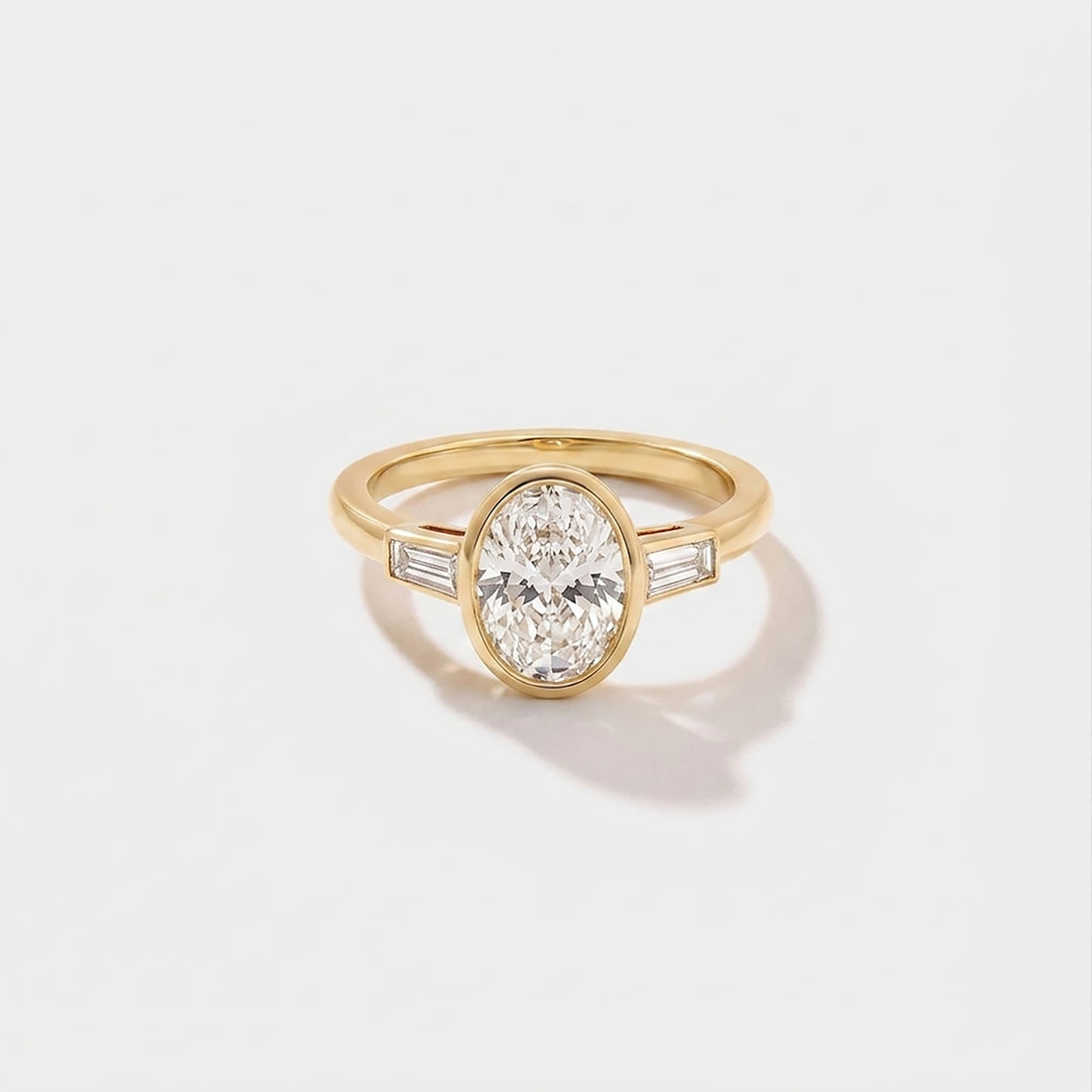 Oval bezel baguette solitaire lab-grown diamond engagement ring in 14K yellow gold by Cove Fine Jewelry