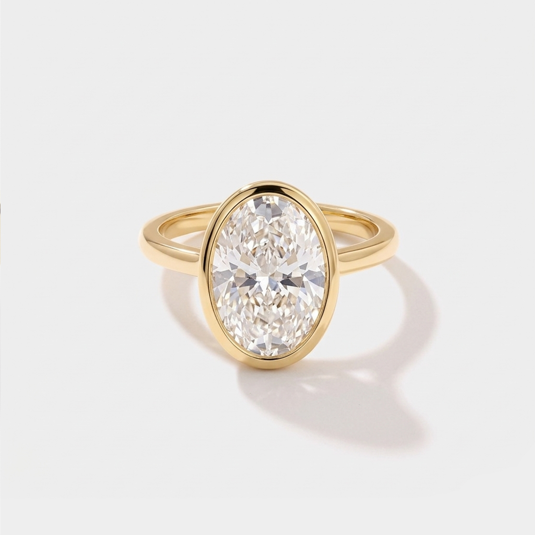 Oval bezel solitaire lab-grown diamond engagement ring in 14K gold by Cove Fine Jewelry
