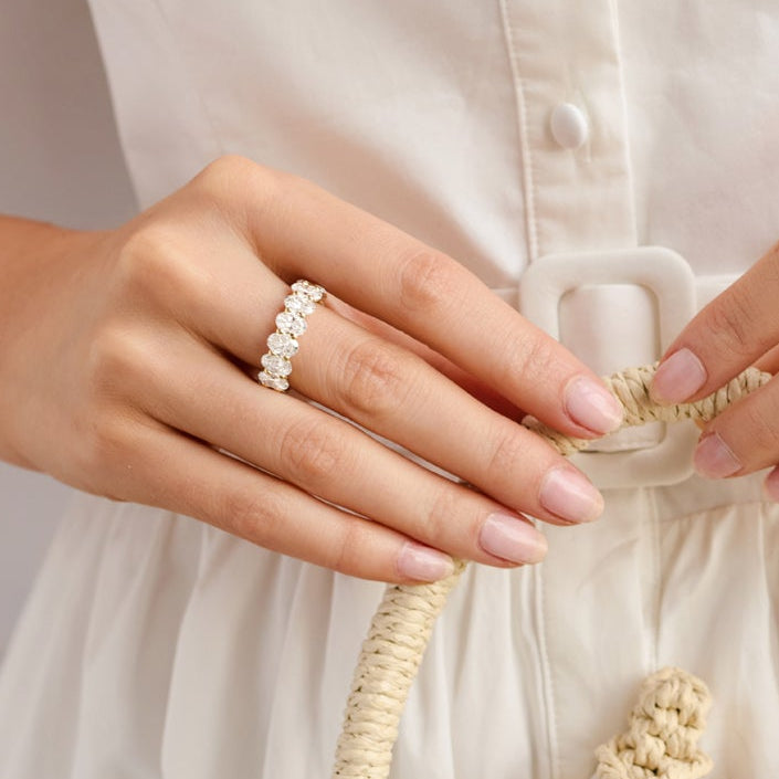Oval-cut diamond eternity ring shown on a model’s hand.