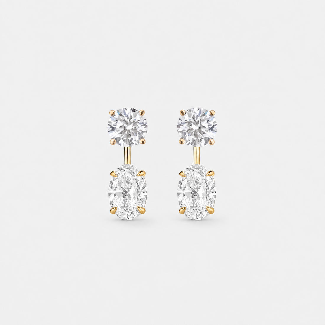 Round lab-grown diamond studs paired with oval lab-grown diamond earring jackets in 14k yellow gold.
