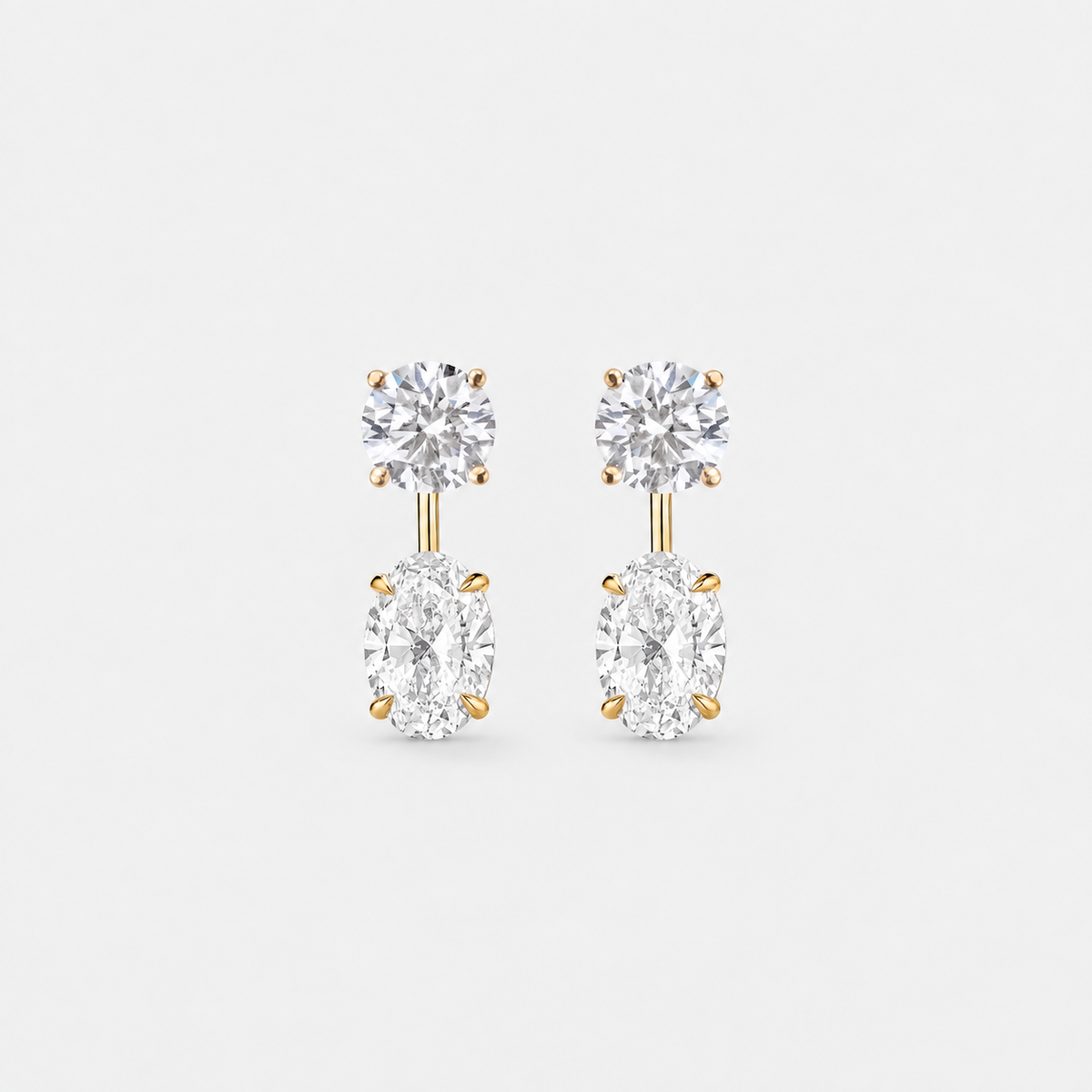 Round lab-grown diamond studs paired with oval lab-grown diamond earring jackets in 14k yellow gold.