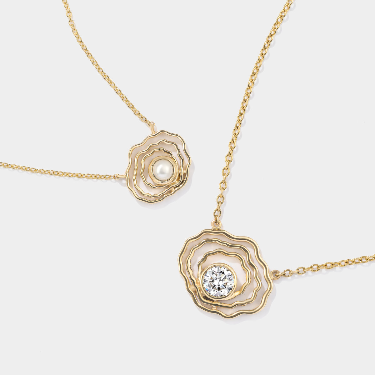 Close-up details of our 14K gold oyster diamond necklace, styled alongside our mini oyster pearl necklace.