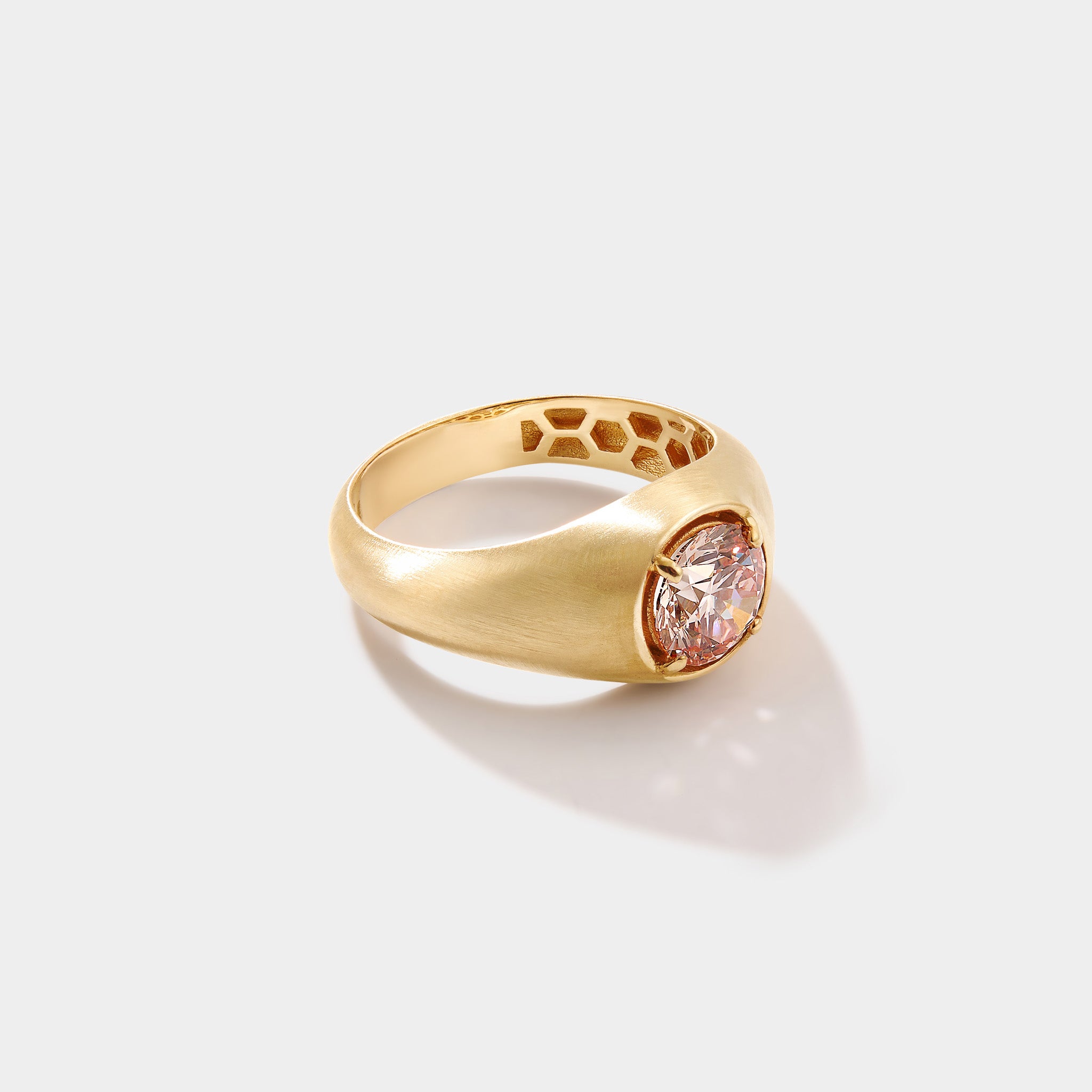 Close up of IGI certified pink diamond solitaire ring in matte 14k yellow gold setting showing color and brilliance