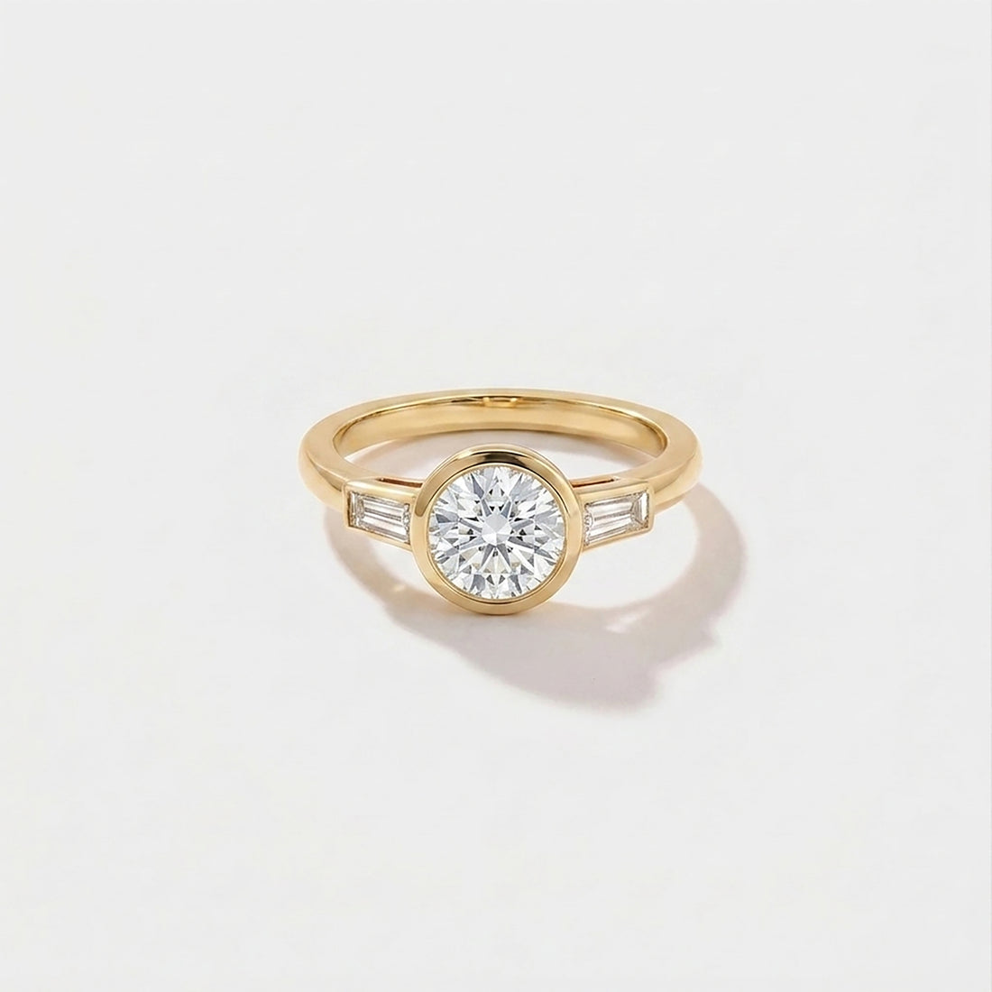 Round bezel baguette solitaire lab-grown diamond engagement ring in 14K yellow gold by Cove Fine Jewelry