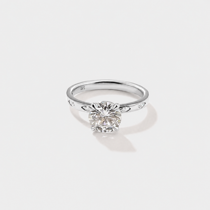 Round lab-grown diamond engagement ring accented with marquise-cut diamonds along the band.