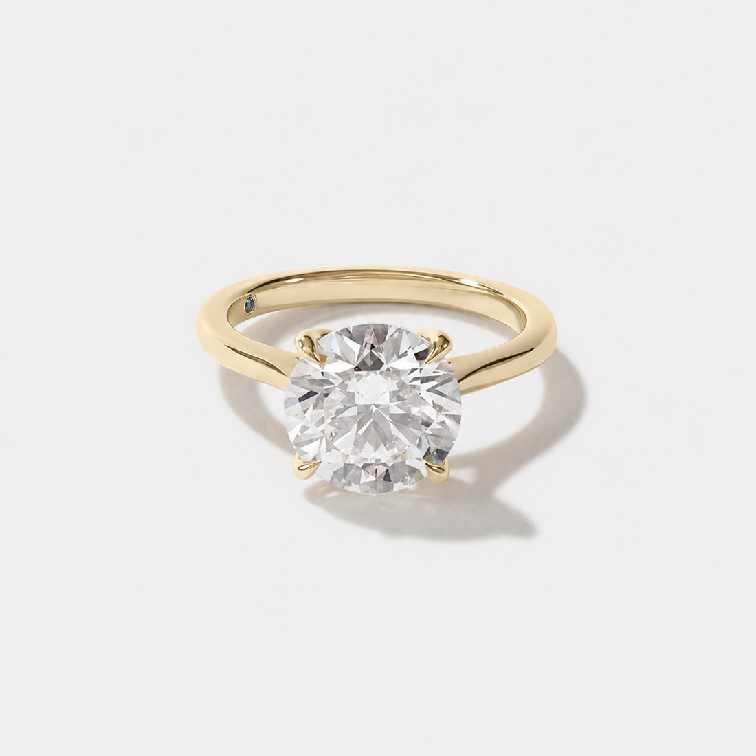 Round lab-grown diamond engagement ring with a sculptural tulip setting and signature blue diamond inside the band.