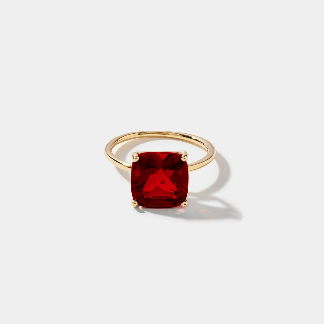 Cushion cut ruby statement ring with 10 mm lab grown ruby gemstone set in polished 14k gold.